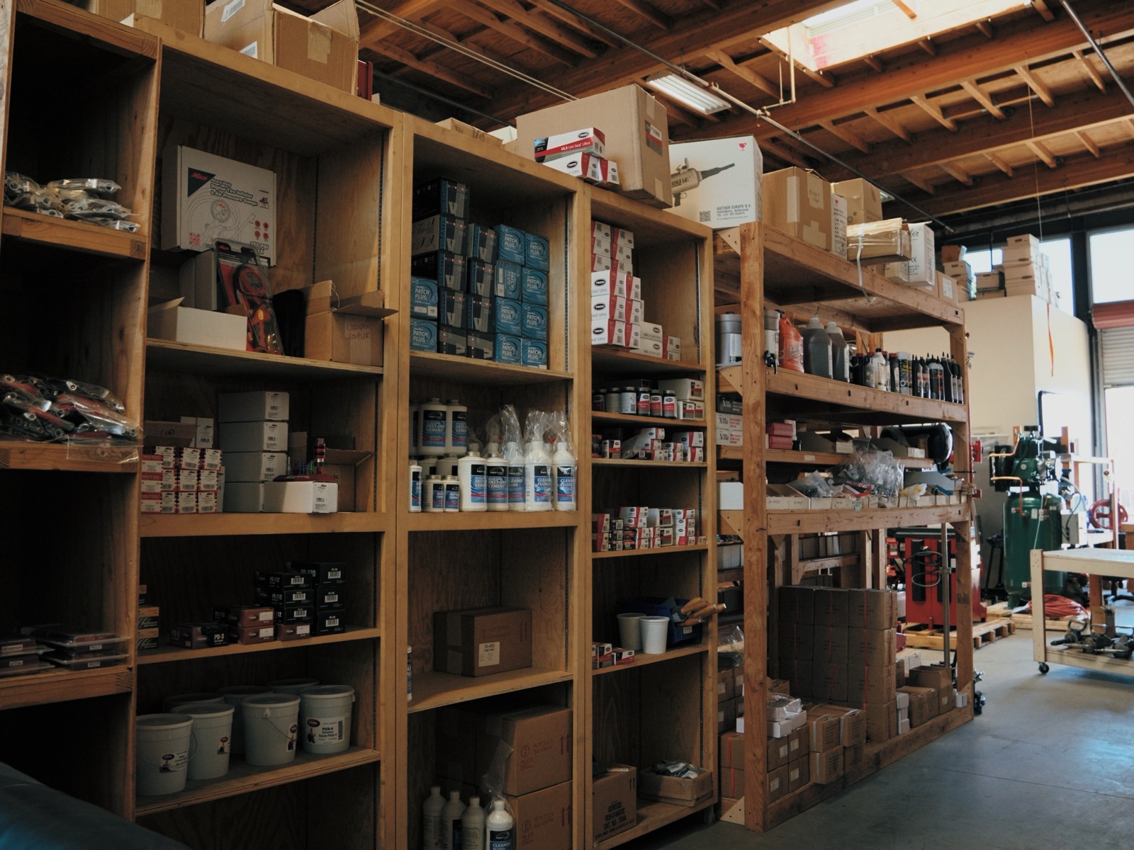 Wooden shelving stocked with tire shop supplies