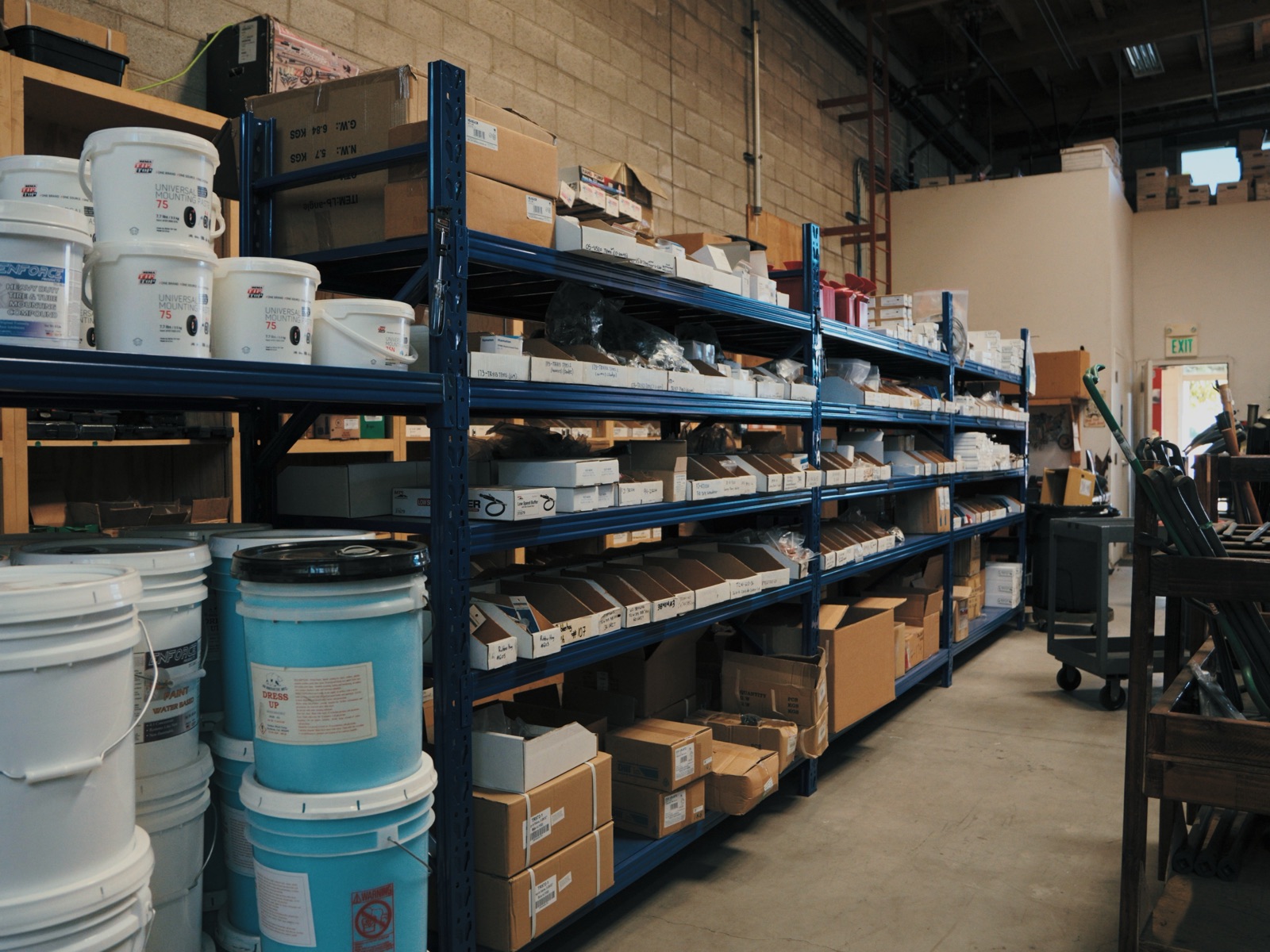 Buckets of tire mounting compound and stocked shelving